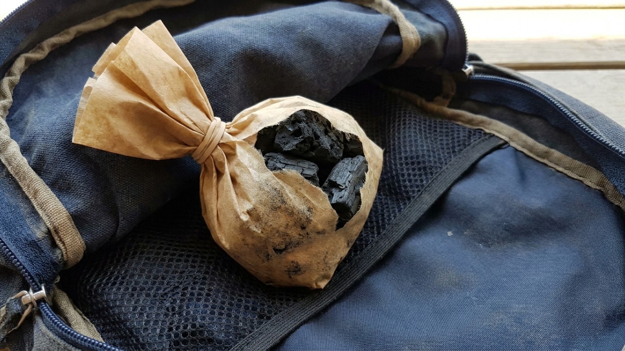 Carregar um pequeno pedaço de carvão ativado embrulhado no filtro de café: para que serve e por que muitos recomendam O filtro de café permite a circulação do ar sem sujar bolsas ou roupas. – Imagem gerada por IA